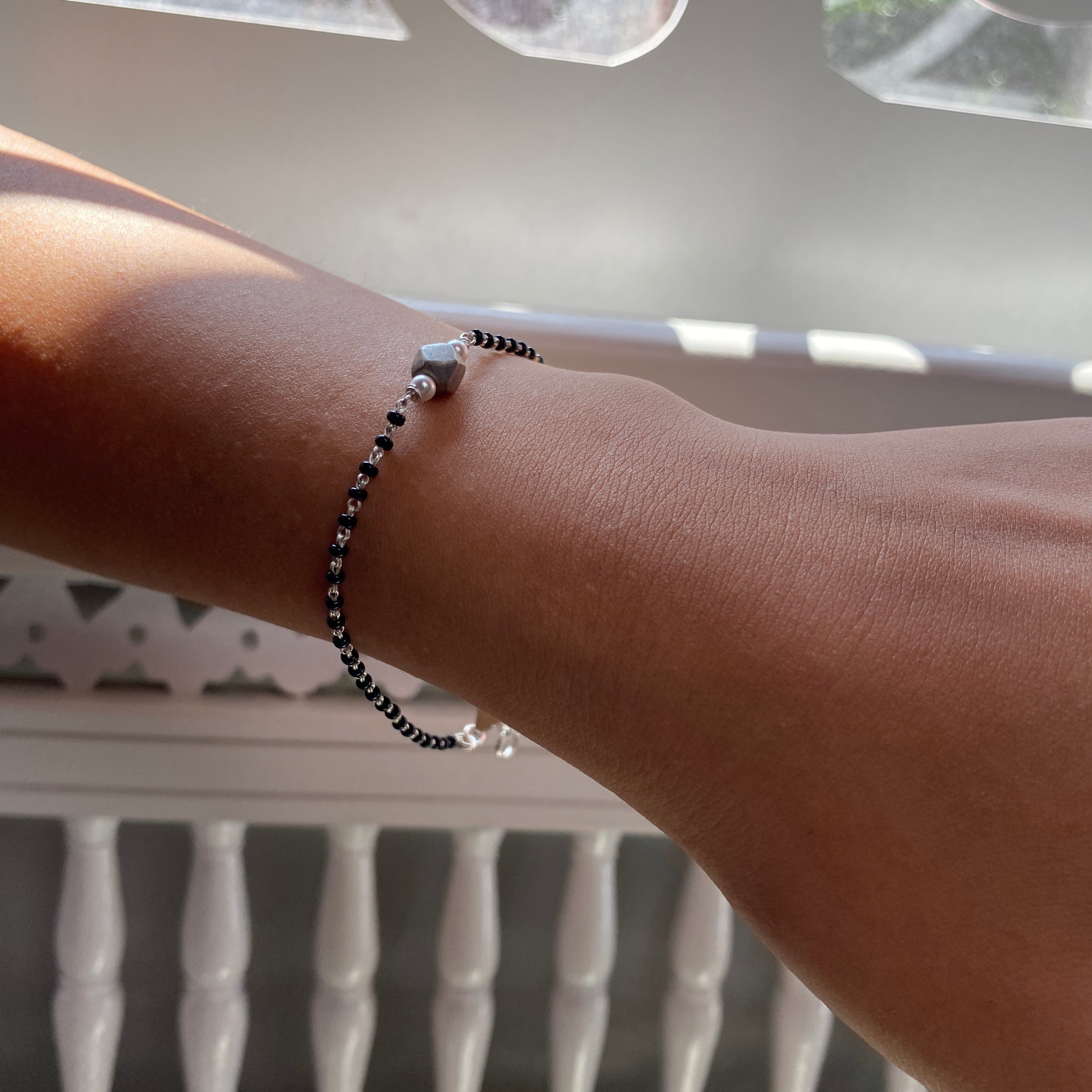 a woman's arm with a beaded bracelet on it