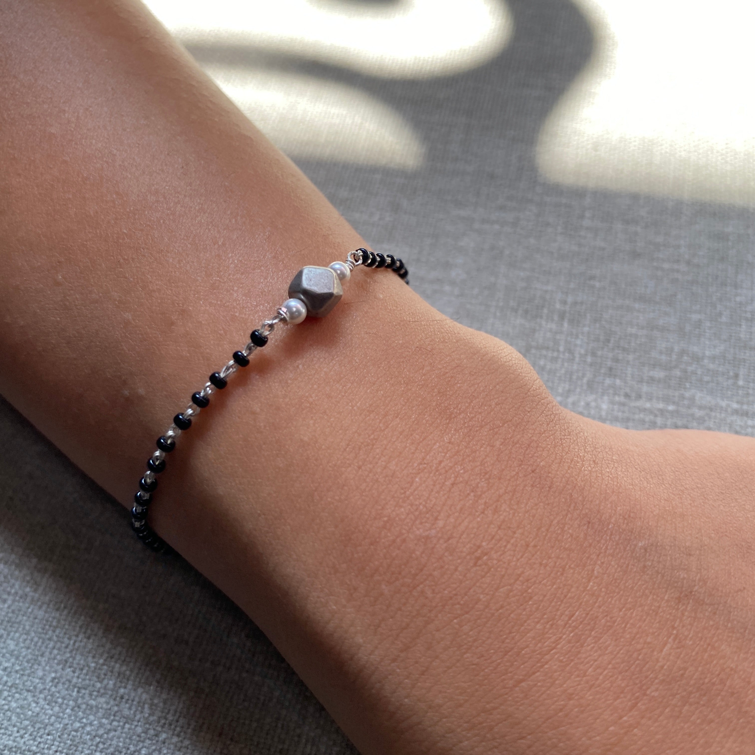 a woman's arm with a beaded bracelet on it