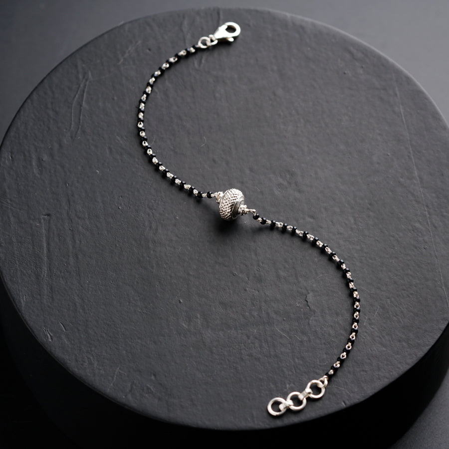 a beaded bracelet on a black surface