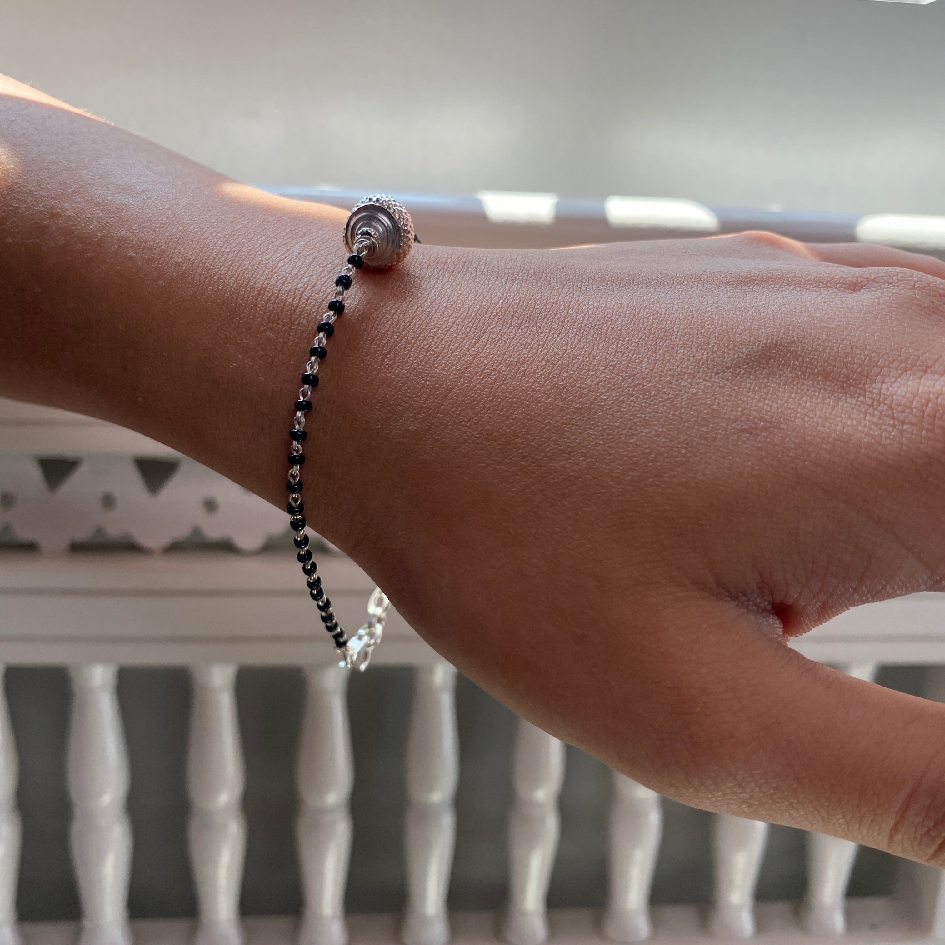 a woman's hand with a beaded bracelet on it