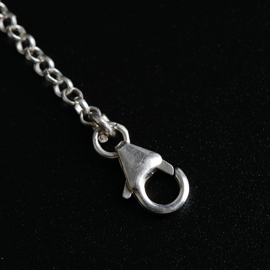 a close up of a metal object on a chain
