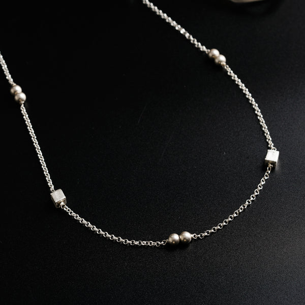 a close up of a necklace on a black surface