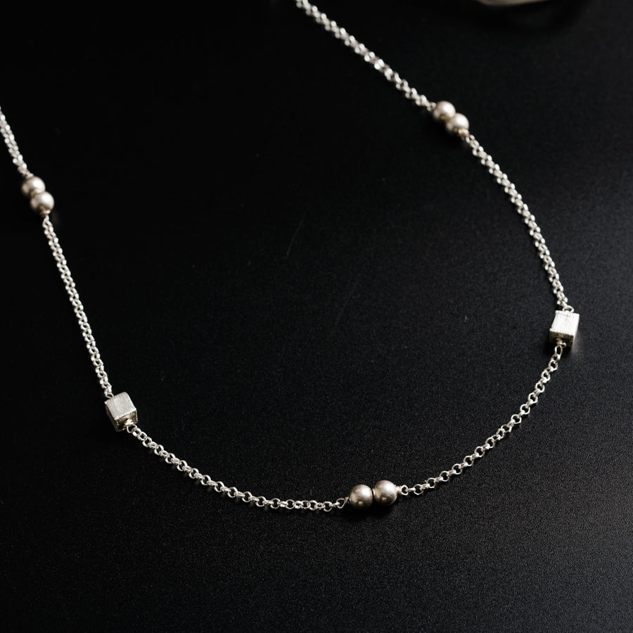 a close up of a necklace on a black surface