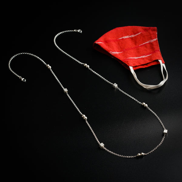 a red cloth and a silver chain on a black surface