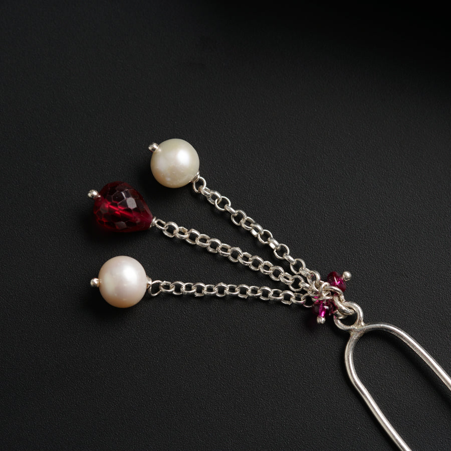 a close up of a pair of earrings on a black surface