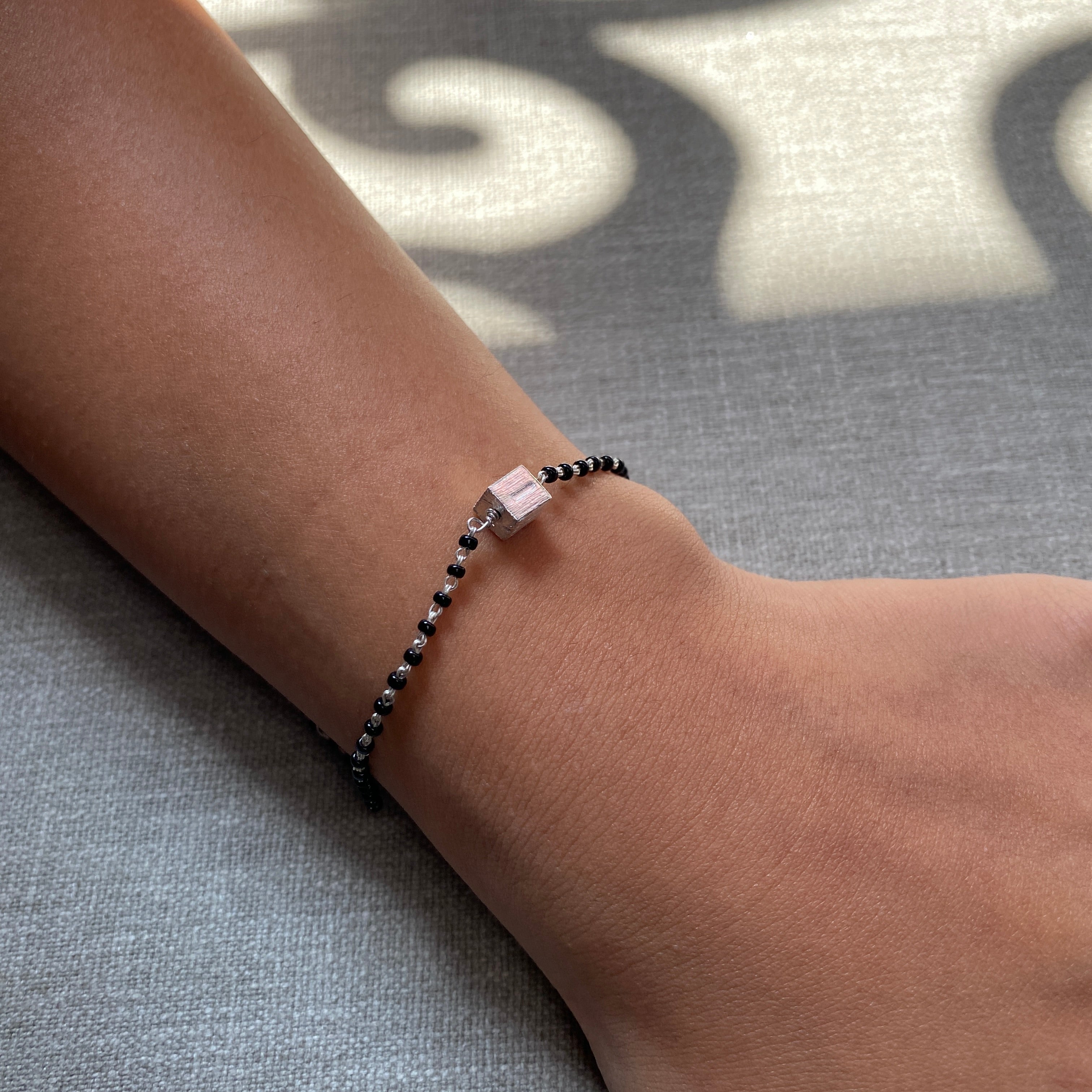 a person wearing a bracelet with a cross on it
