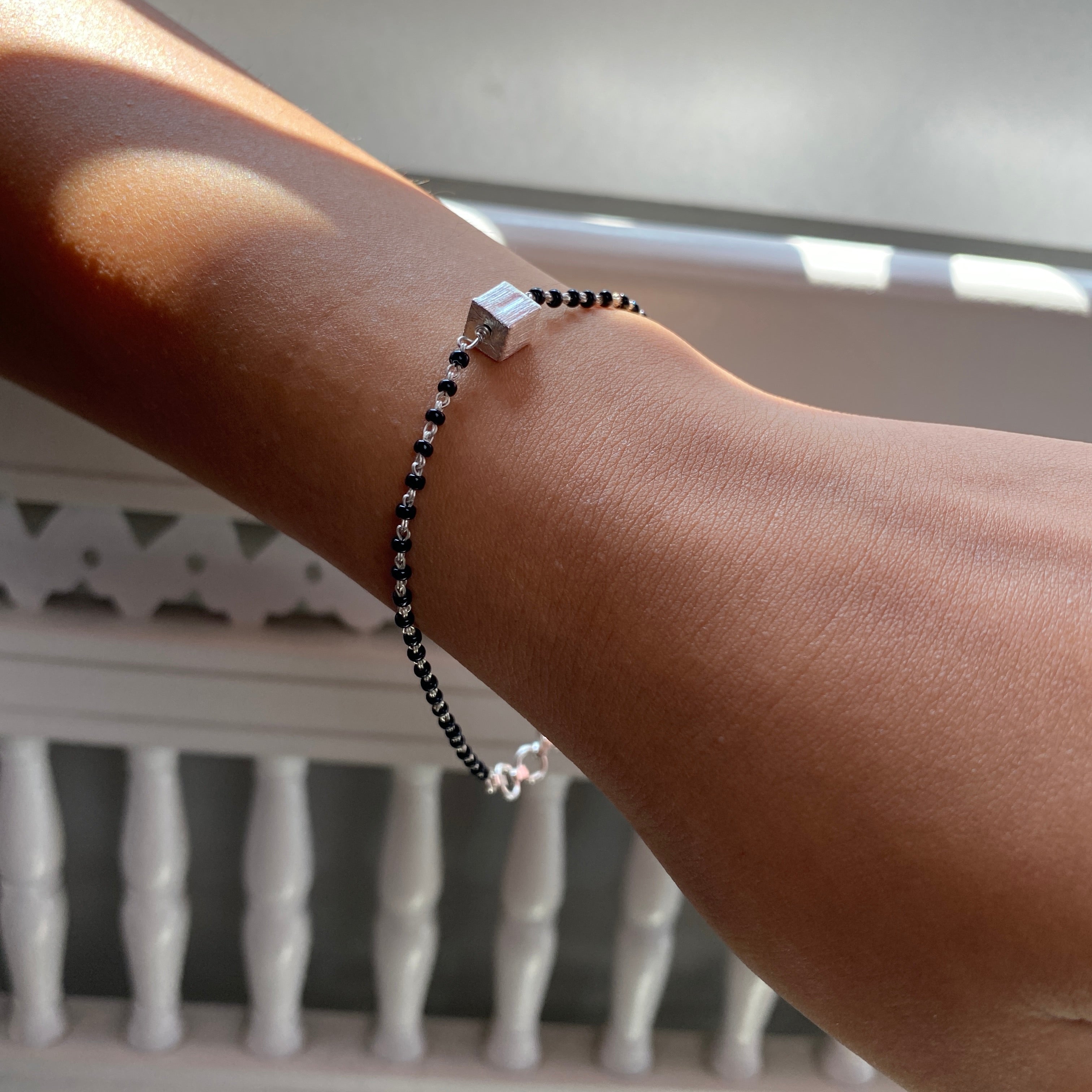 a woman's arm with a beaded bracelet on it
