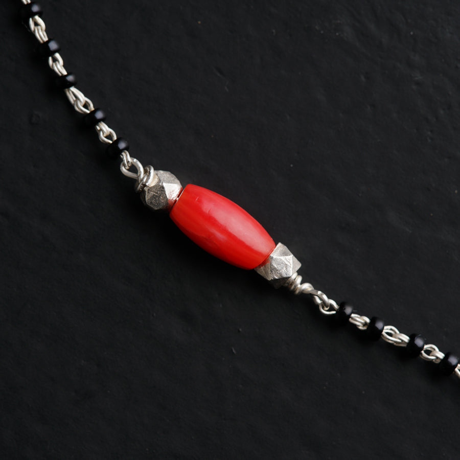 a red beaded necklace on a black surface