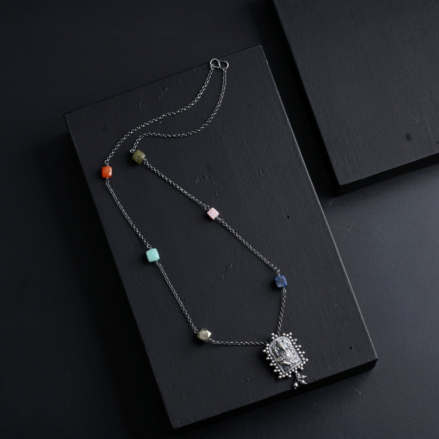 a necklace with beads and a pendant hanging from it