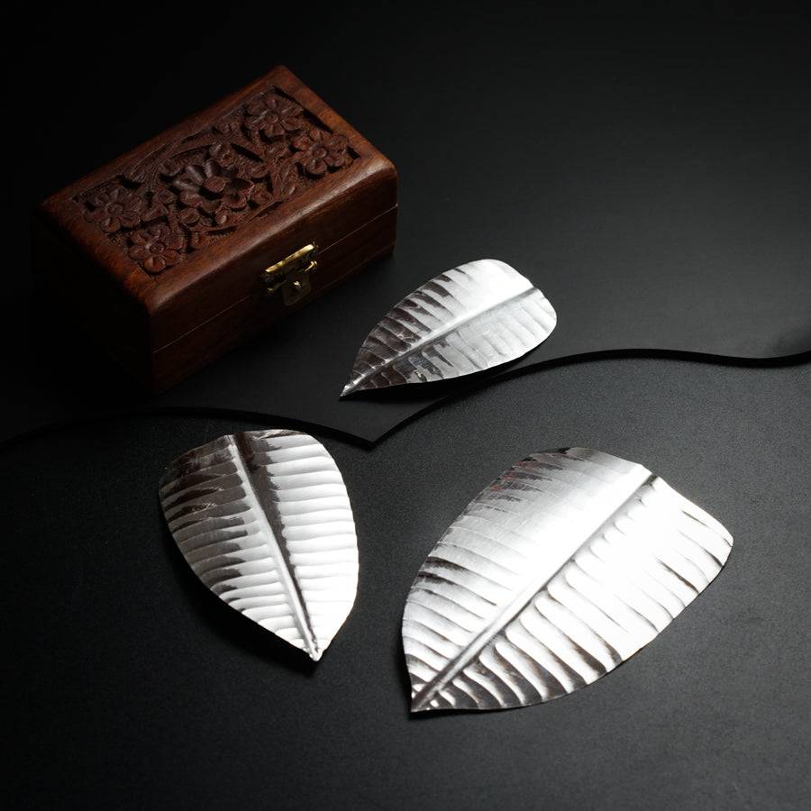 three pieces of metal sitting on top of a table