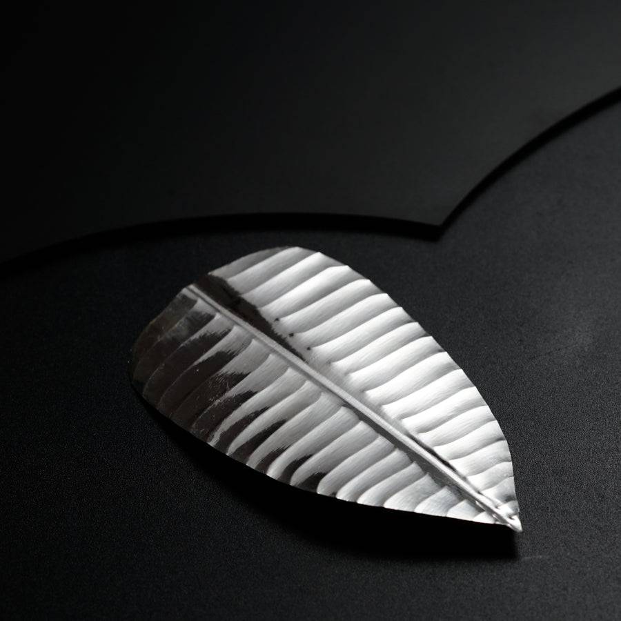 a piece of metal that is on a black surface