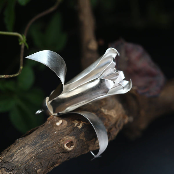 a piece of metal sitting on top of a tree branch