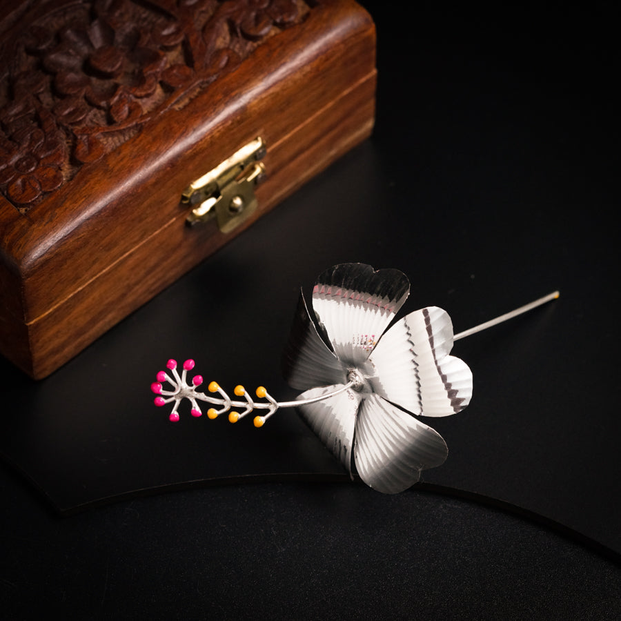 a white flower on a black table next to a wooden box