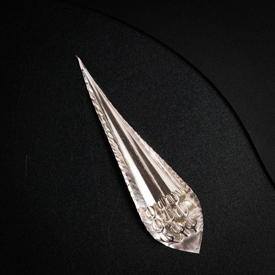 a piece of silver foil sitting on top of a black surface