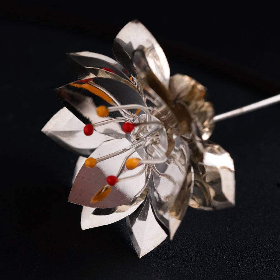 a close up of a metal flower on a black surface