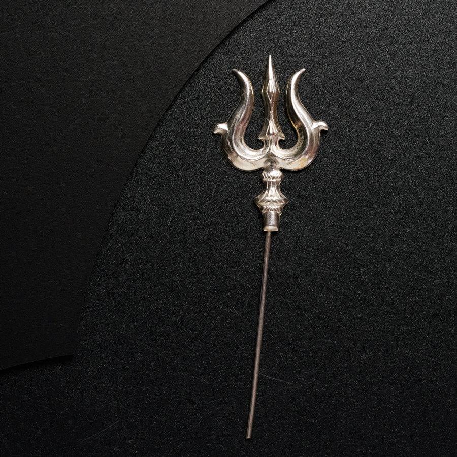 a metal hook with a long handle on a black surface