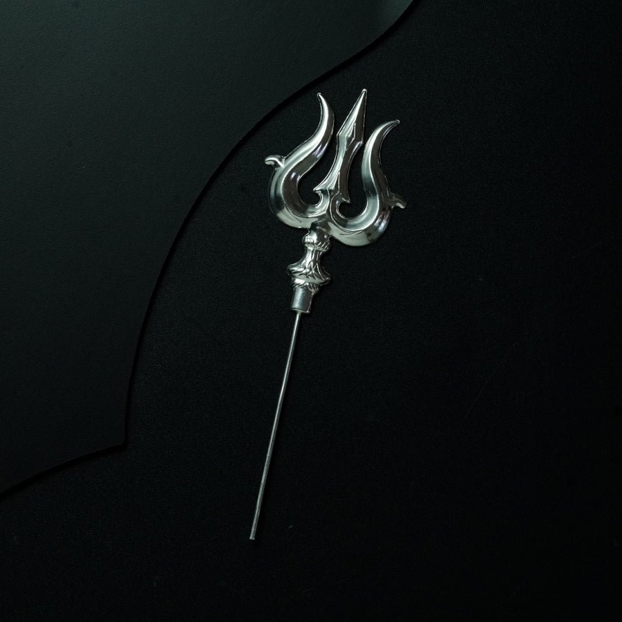 a metal hook with a long handle on a black surface
