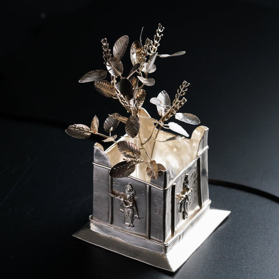 a small silver box with a plant in it