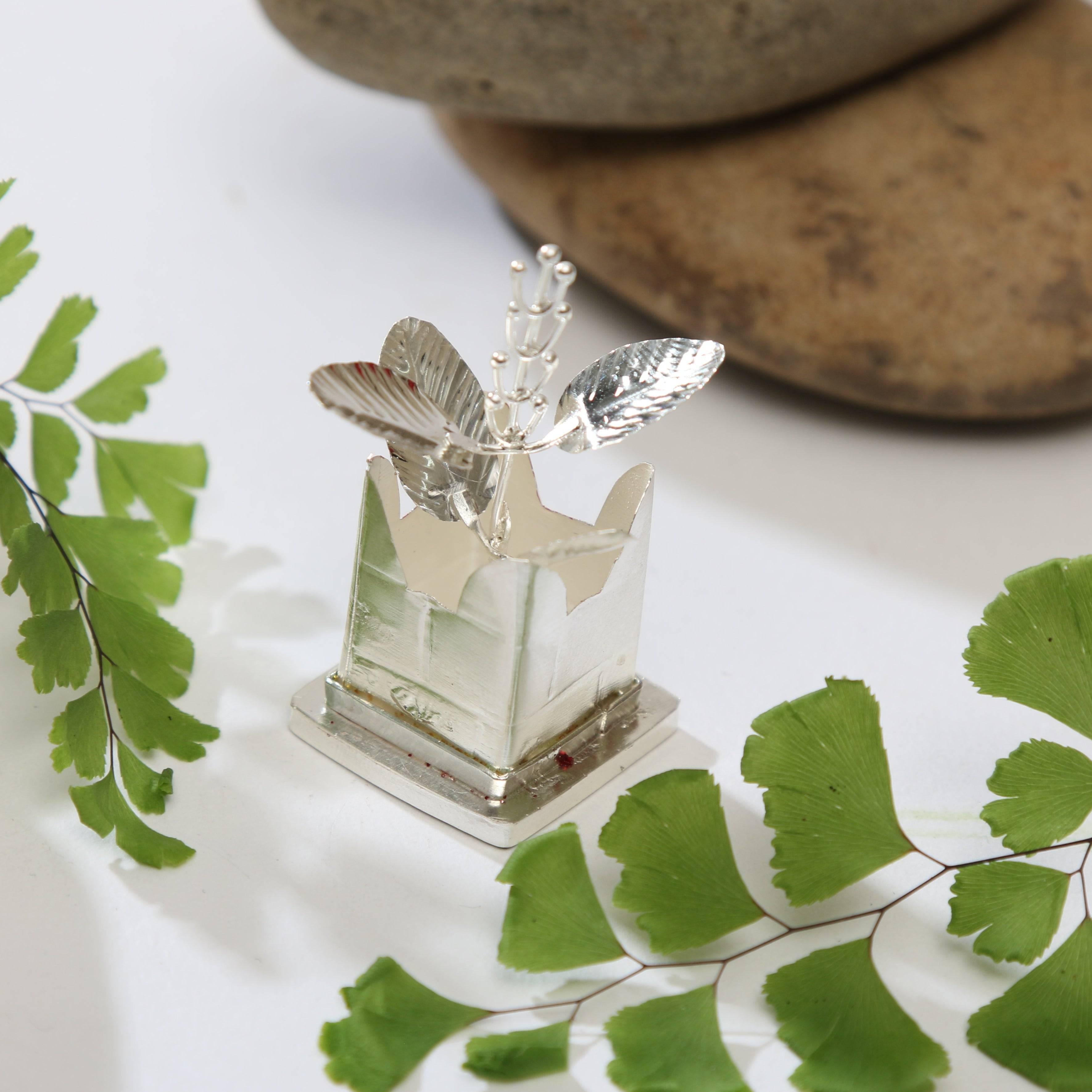 a glass vase with a silver butterfly on top of it
