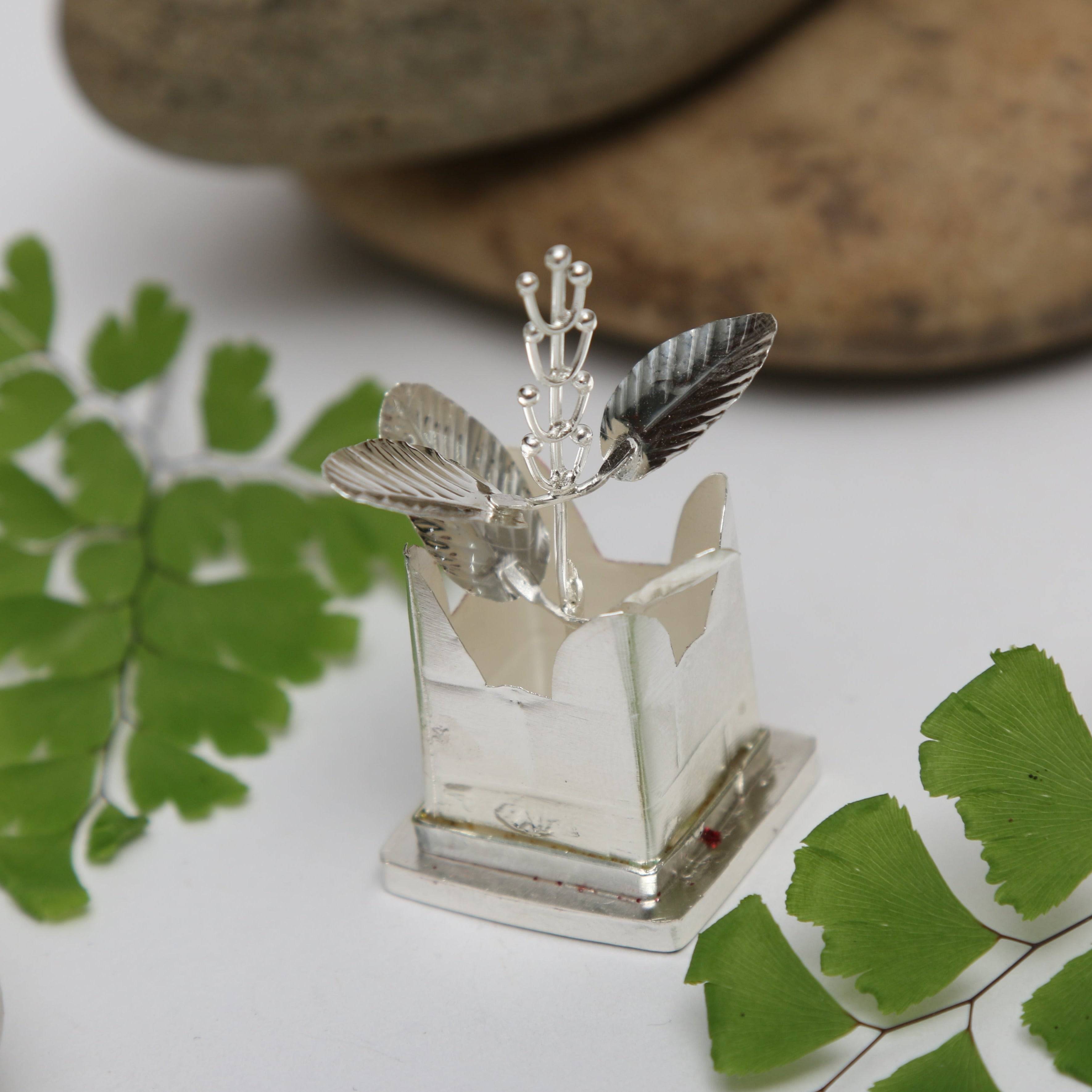 a small glass vase with a feather on top of it
