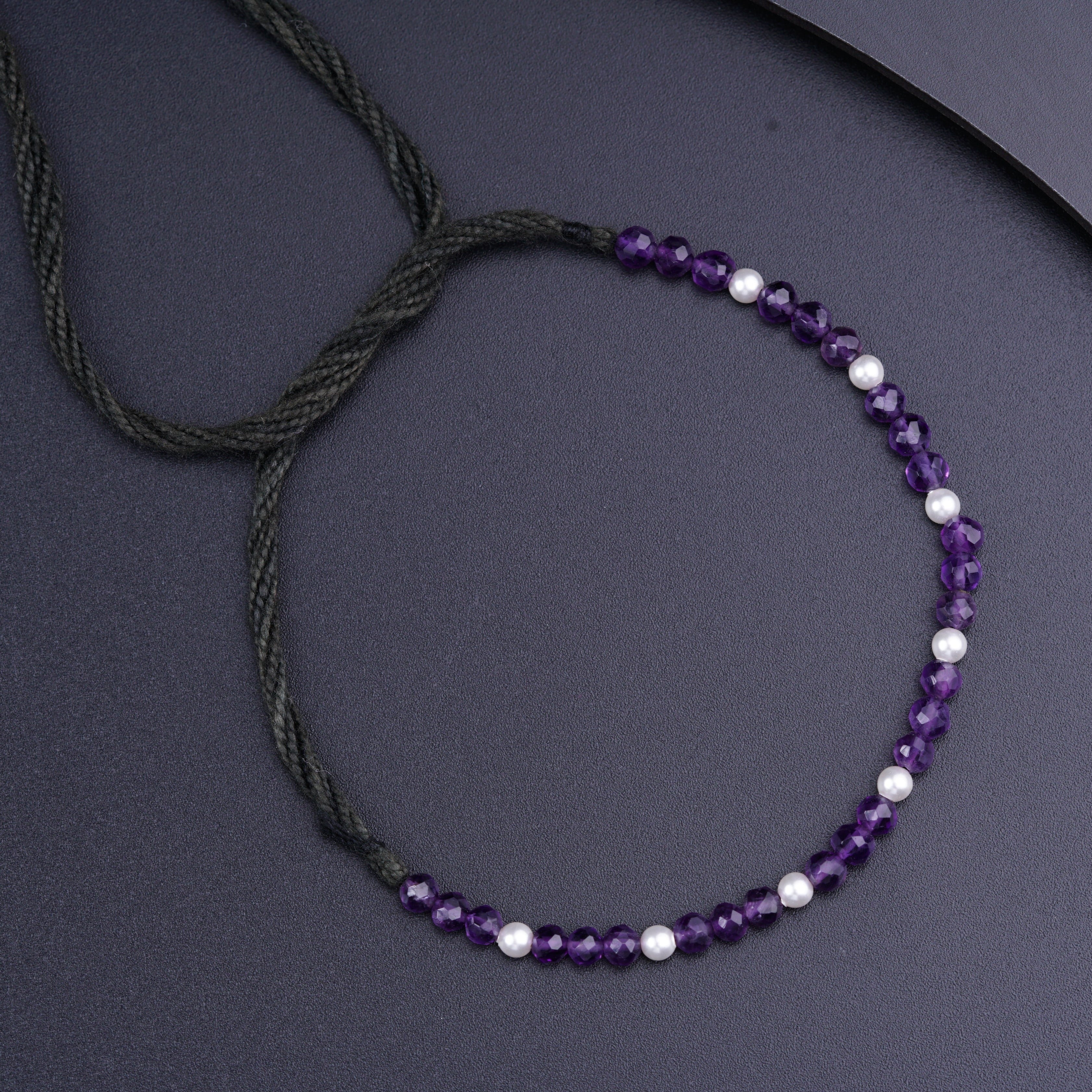 a purple beaded necklace with white pearls