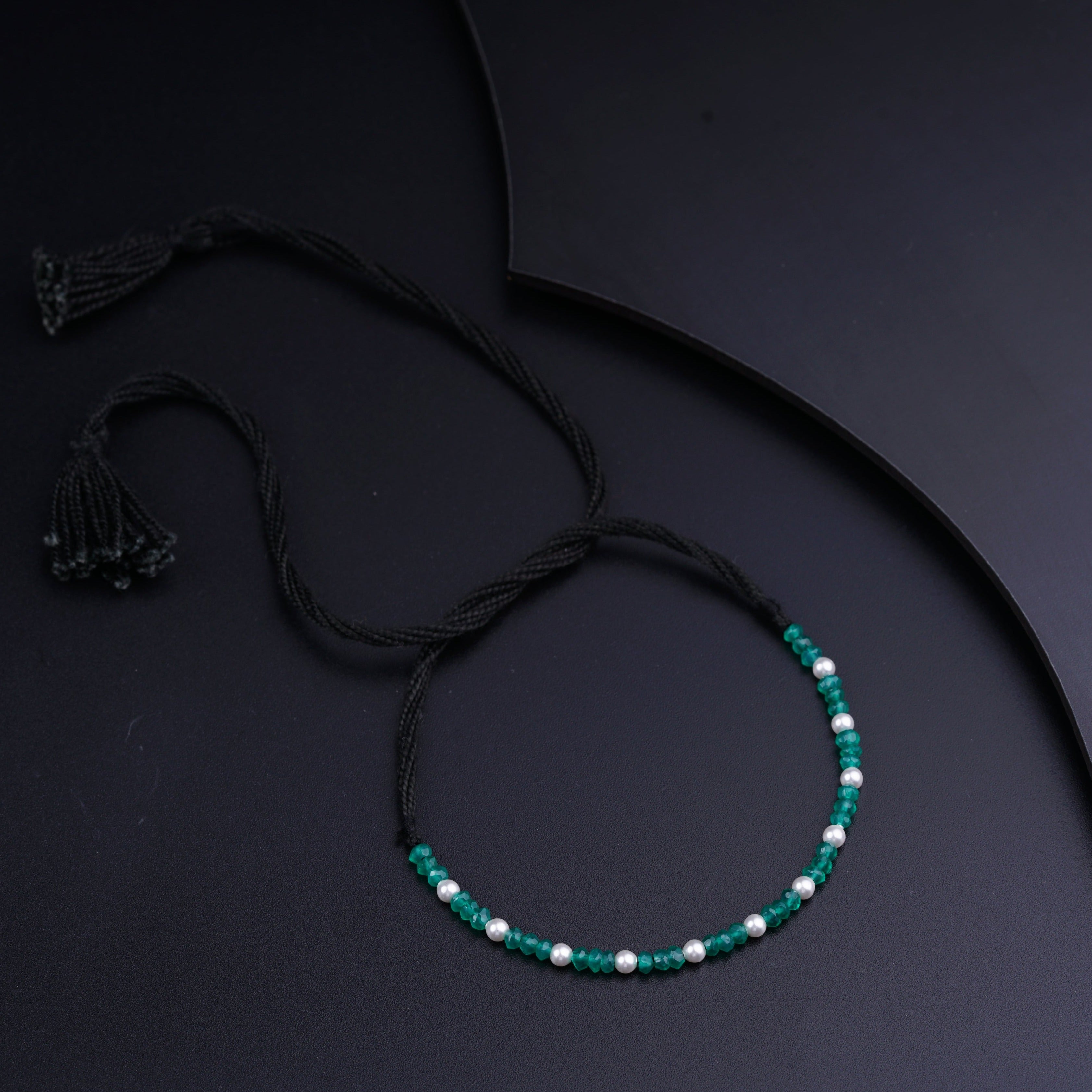 a green beaded necklace with a tassel
