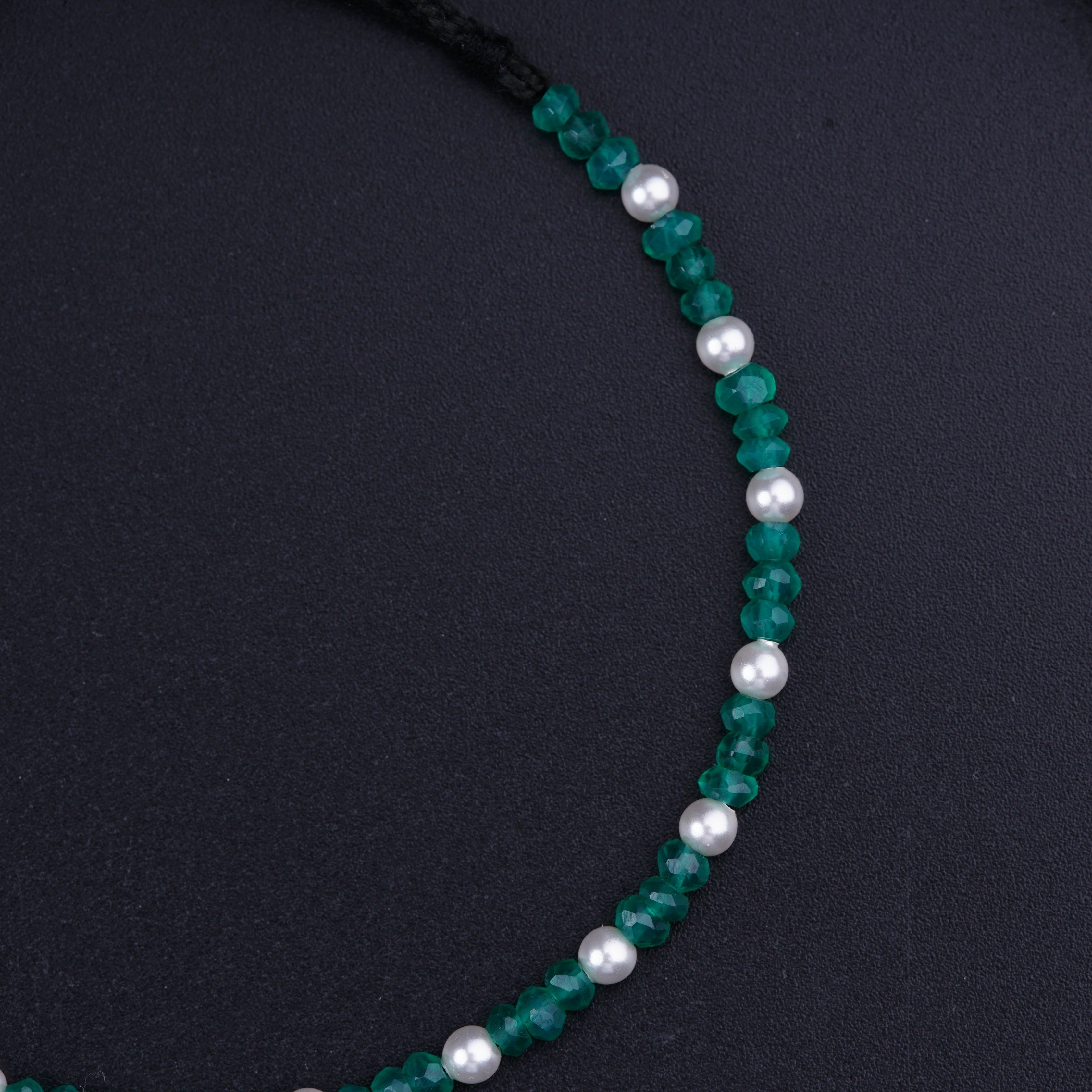 a necklace with pearls and green glass beads