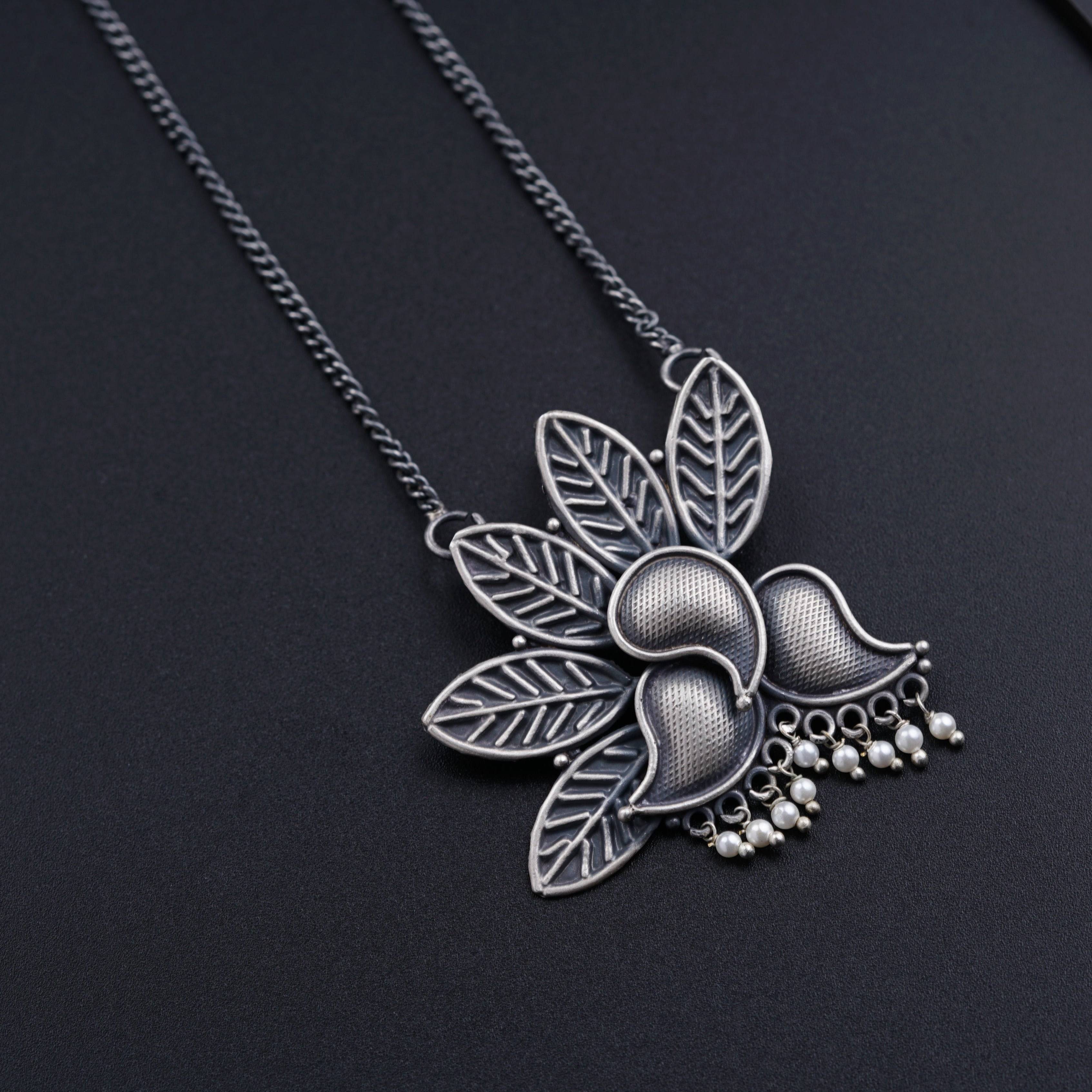 a close up of a necklace on a black surface