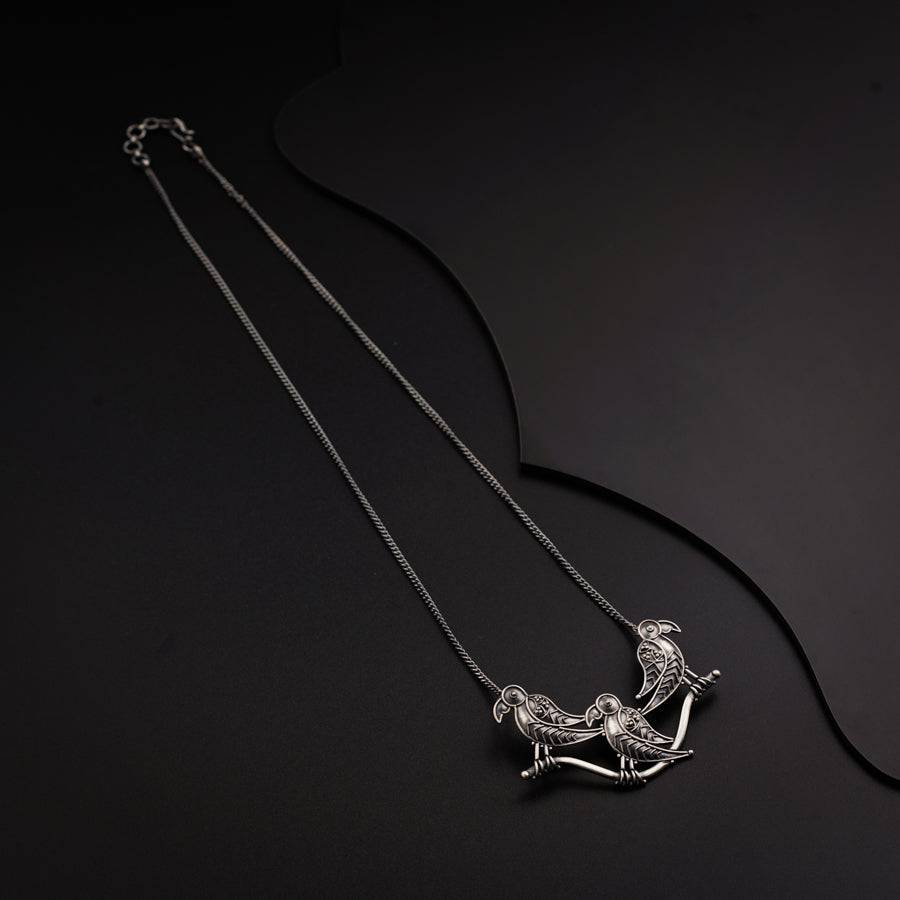 a silver necklace with a horse on it