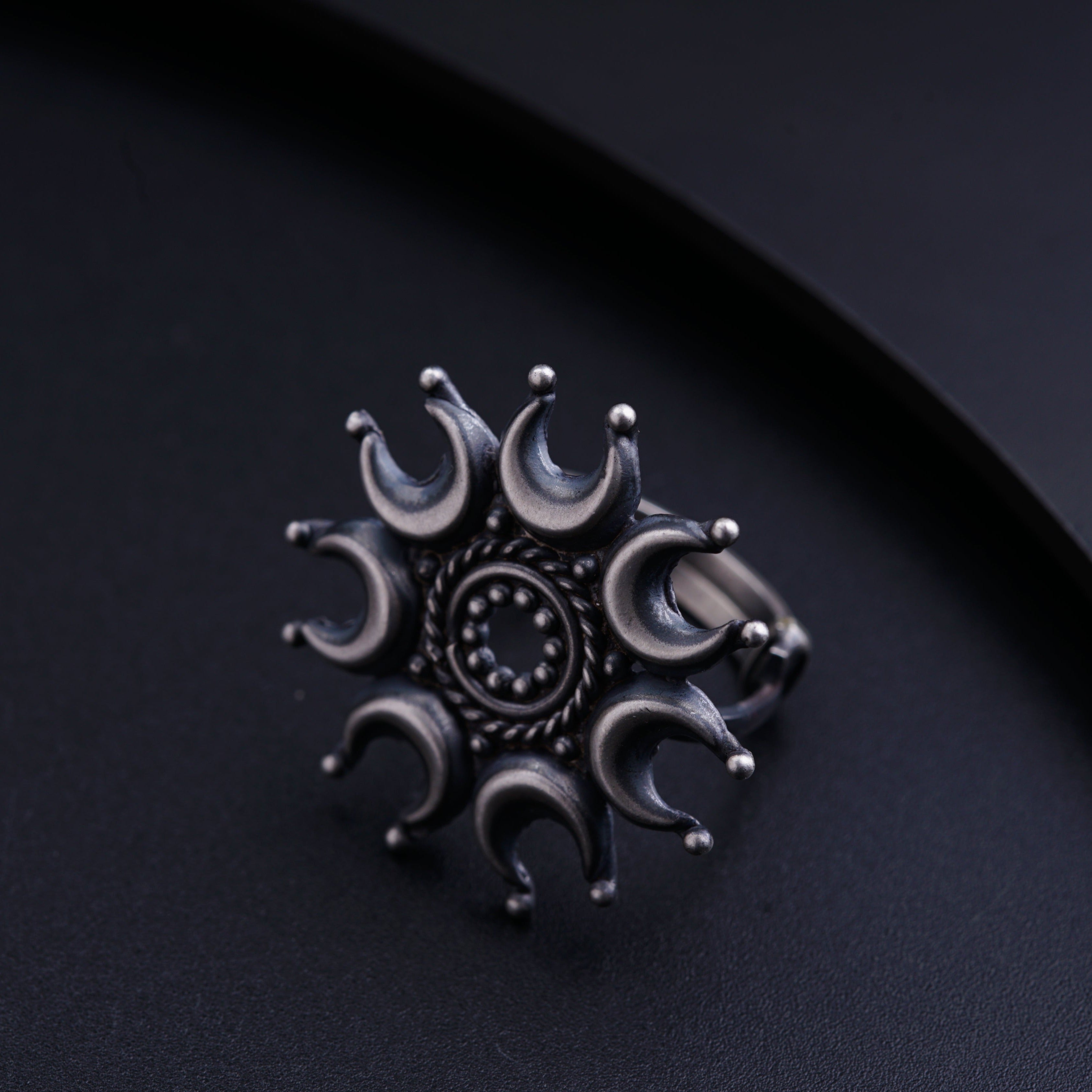 a silver ring with a circular design on it