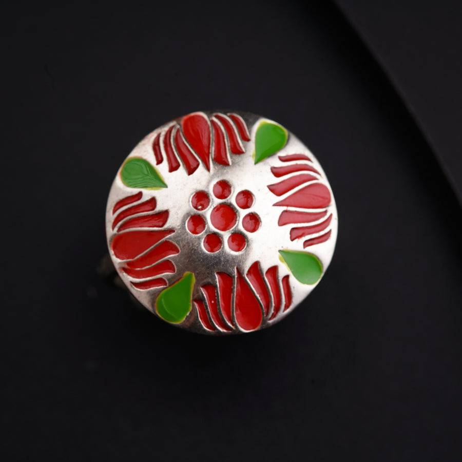 a close up of a red and green flower on a black surface