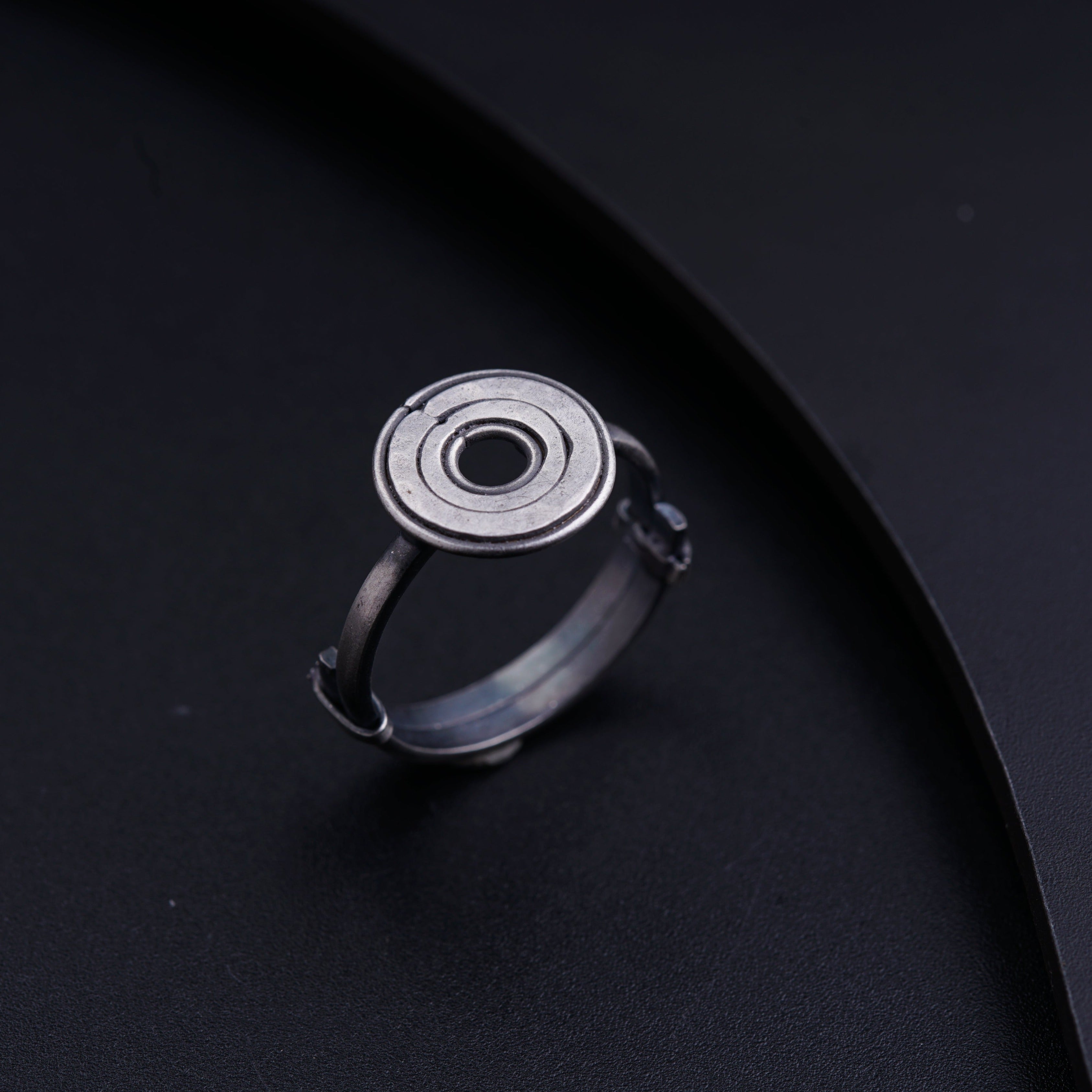a silver ring with a black hole in the middle