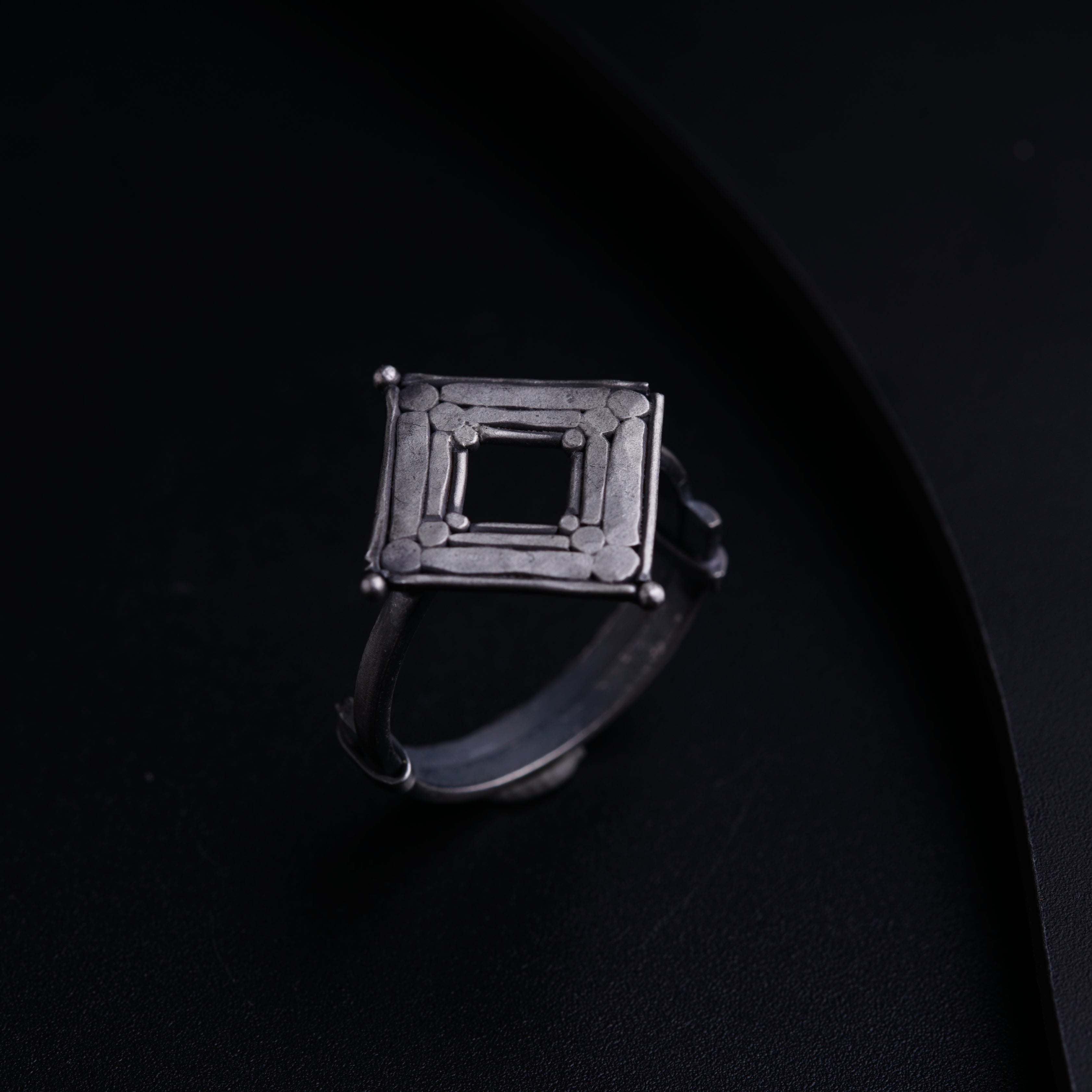 a silver ring with a square design on it