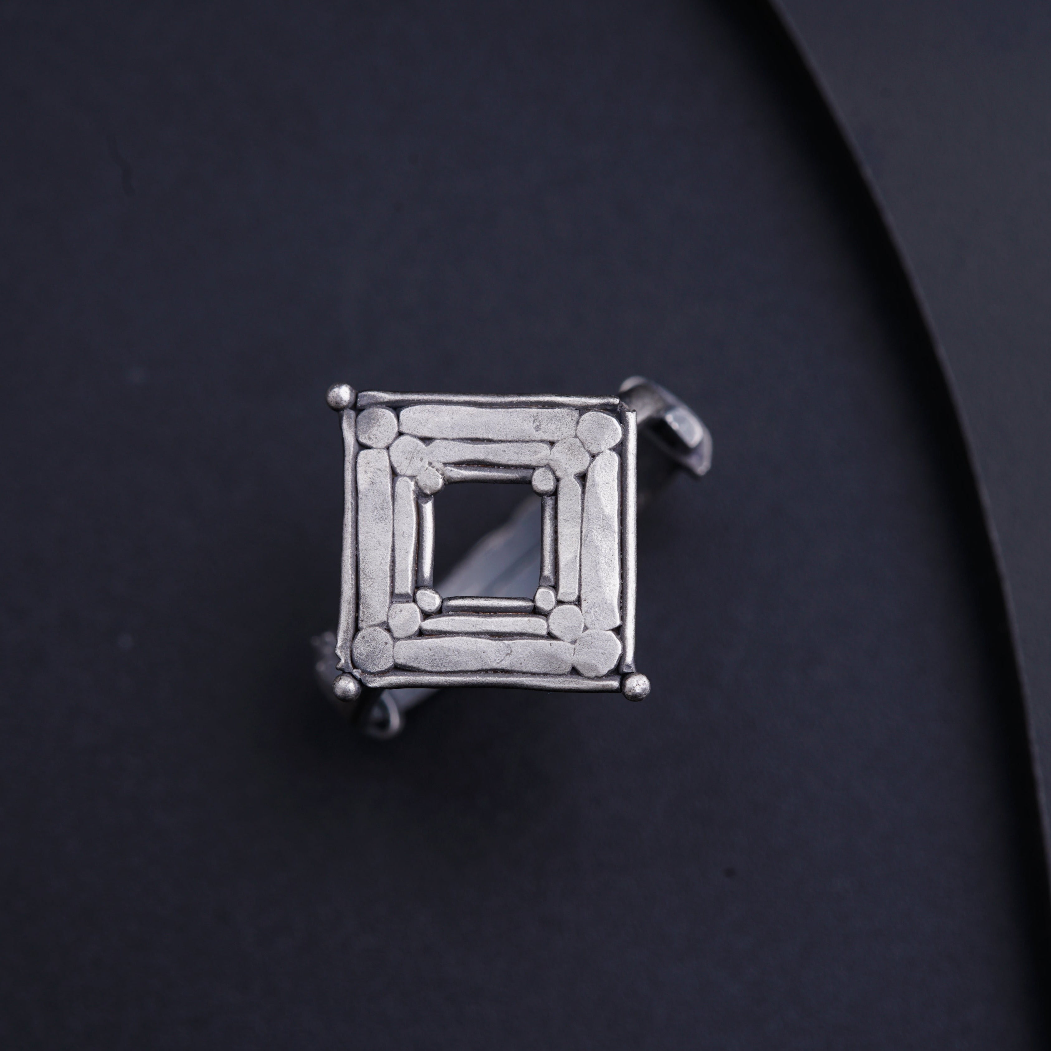 a silver ring with a square design on it