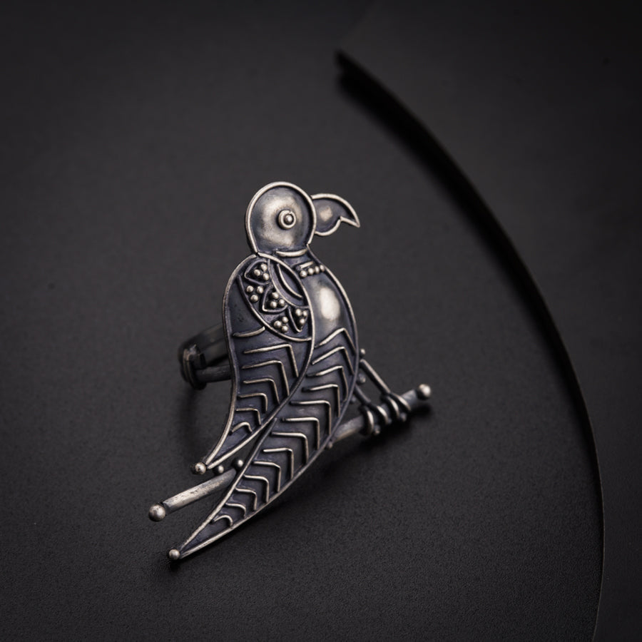 a metal bird brooch sitting on top of a table