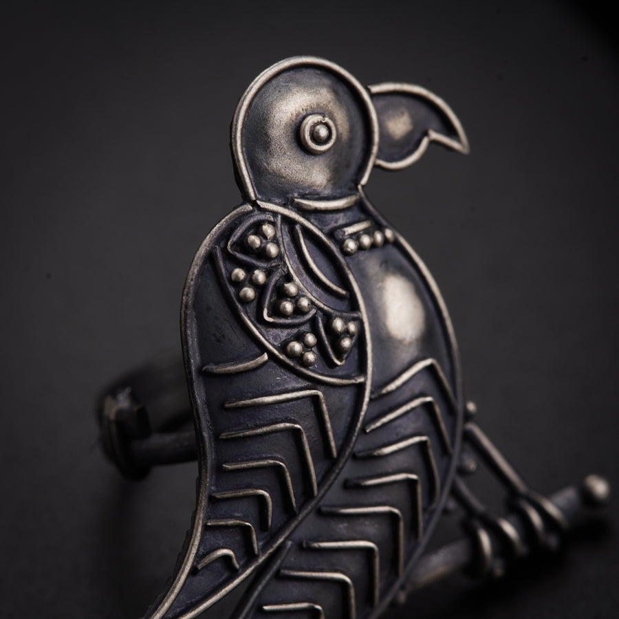 a metal bird sitting on top of a table