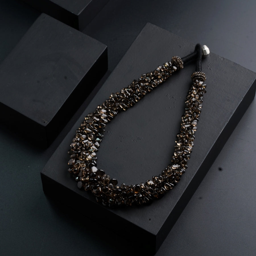 a necklace is displayed on a black surface