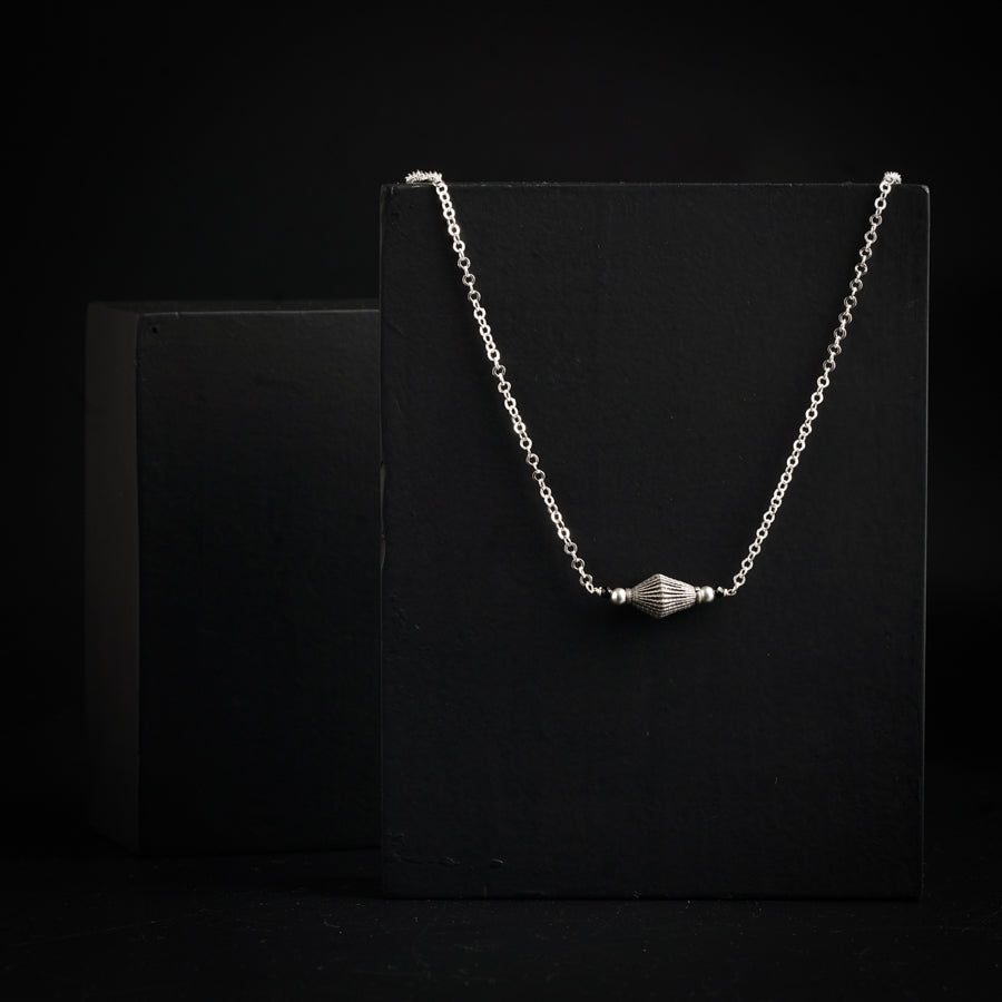 a black box with a silver necklace on it