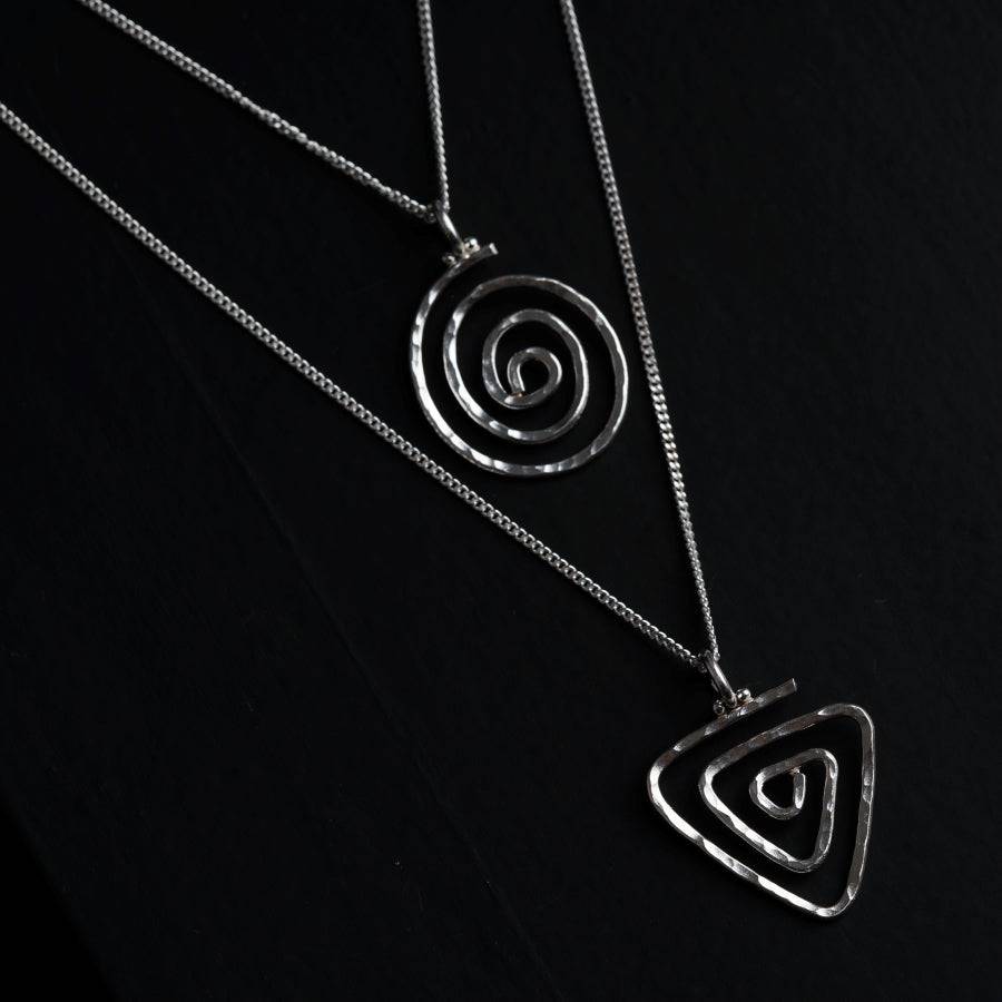 a silver necklace with a spiral design on it