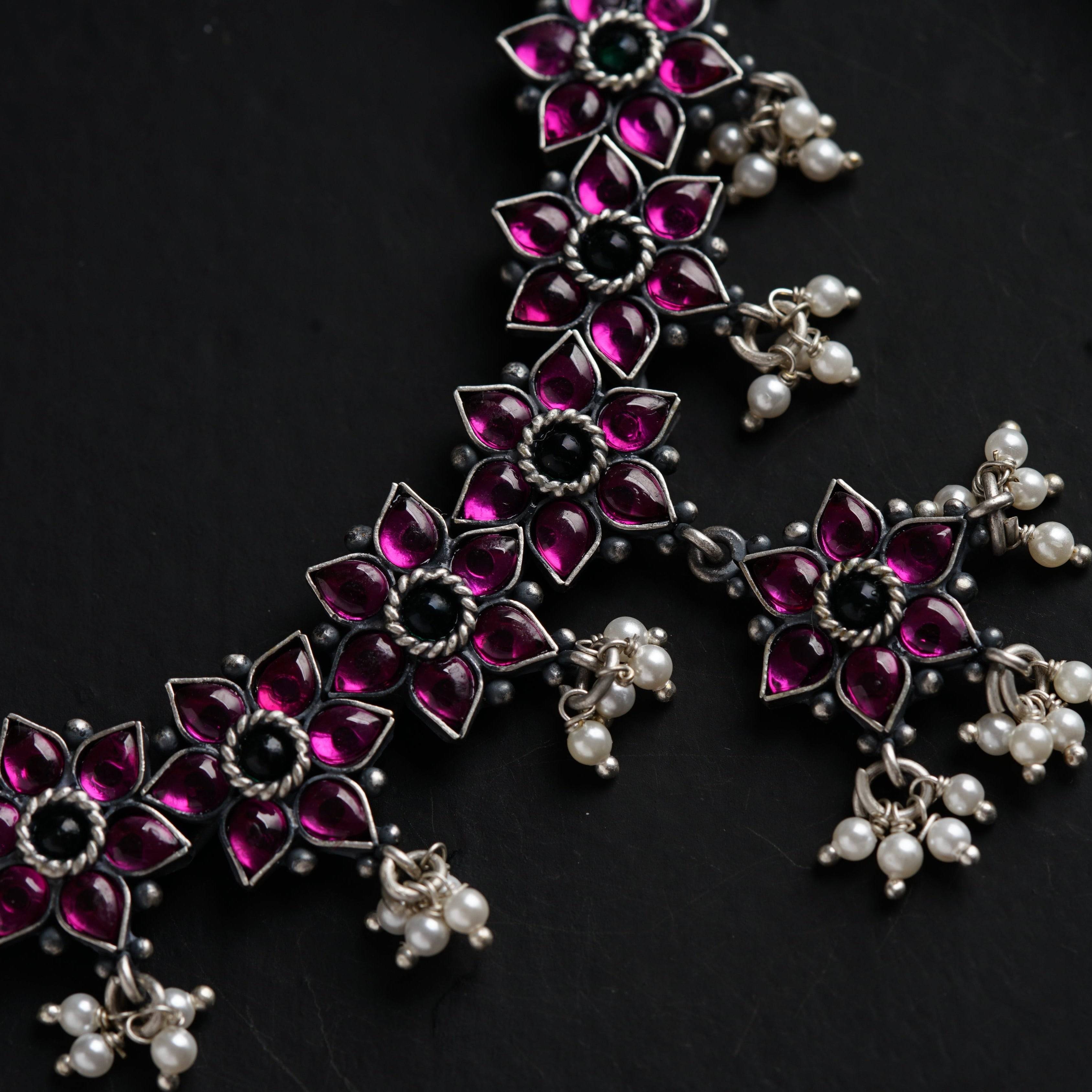 a close up of a necklace on a black surface