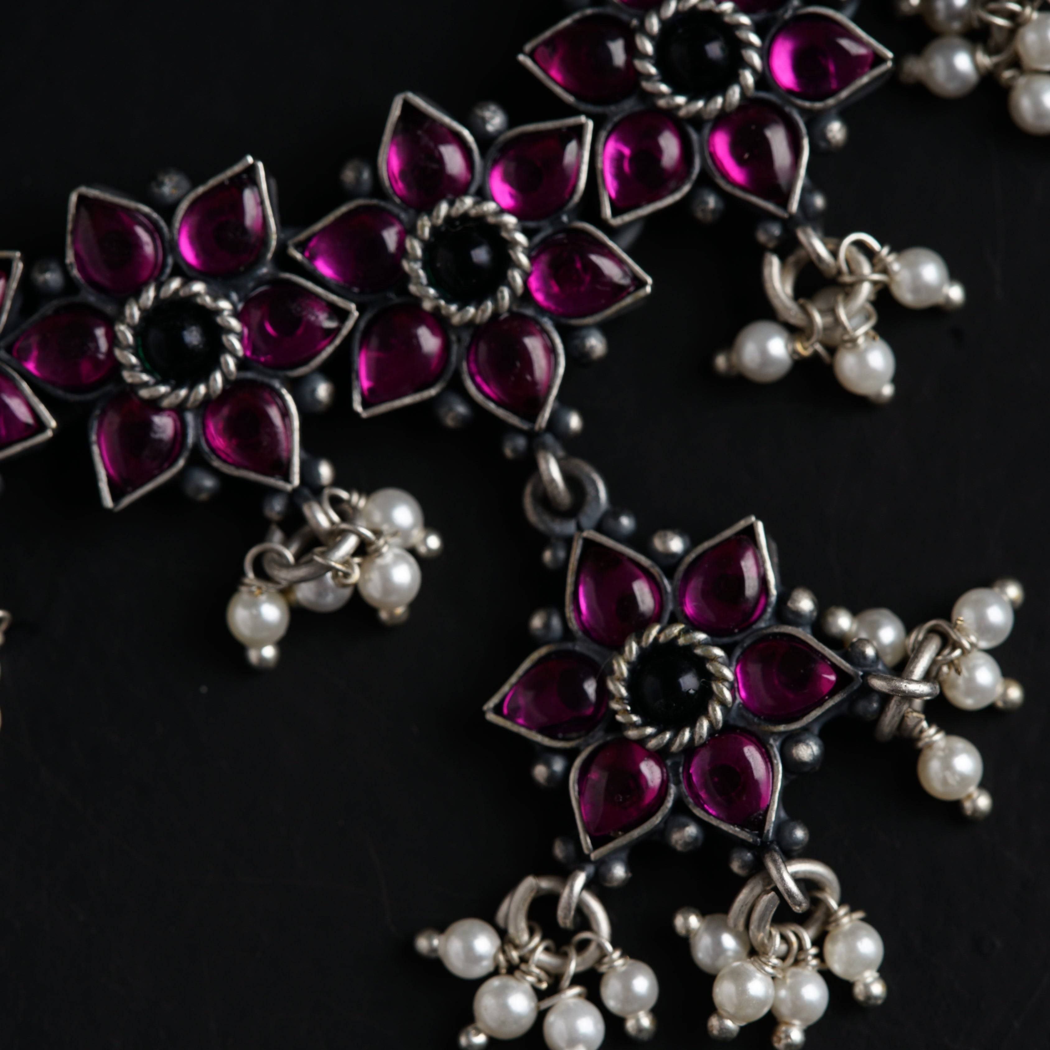 a close up of a necklace on a black surface
