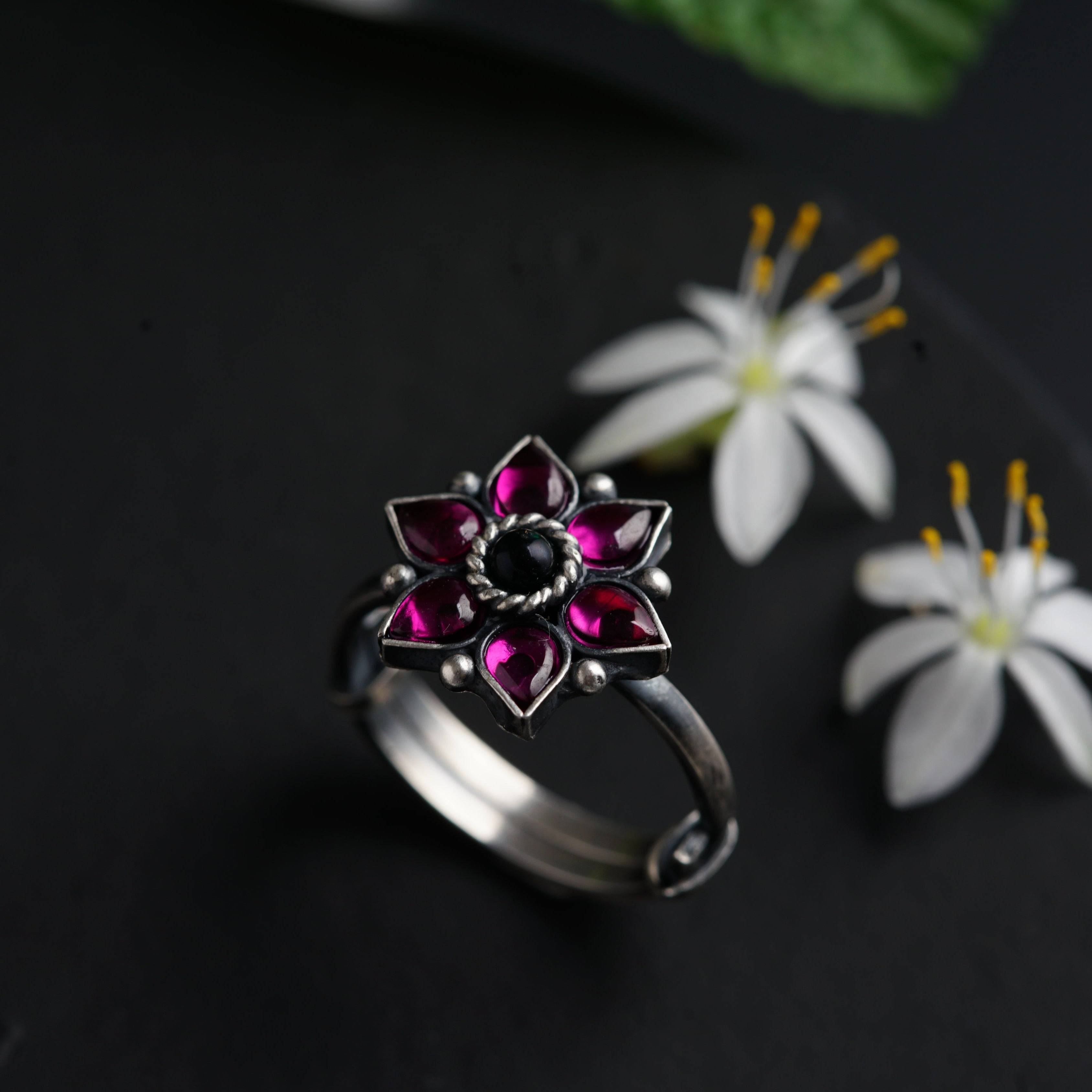 a close up of a ring with flowers in the background