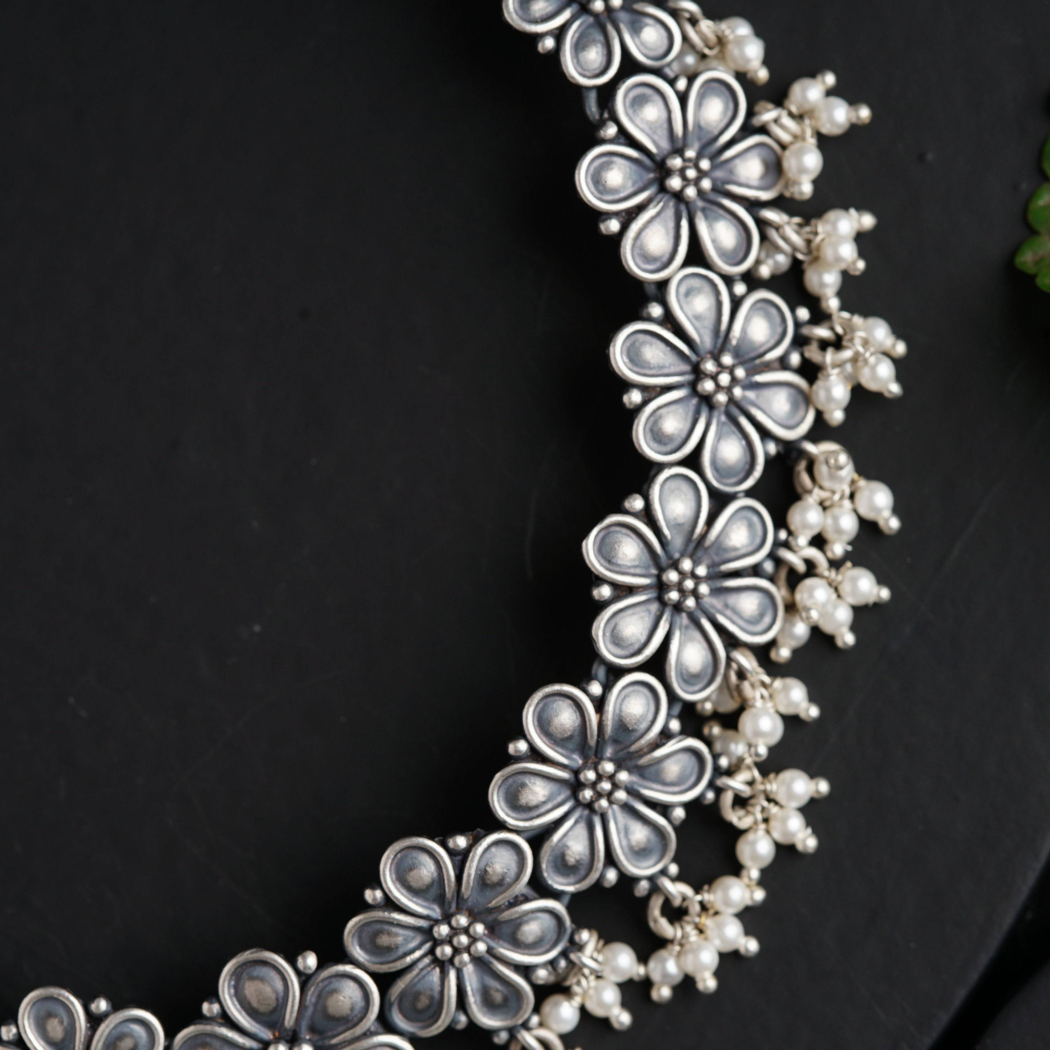 a close up of a necklace on a black surface