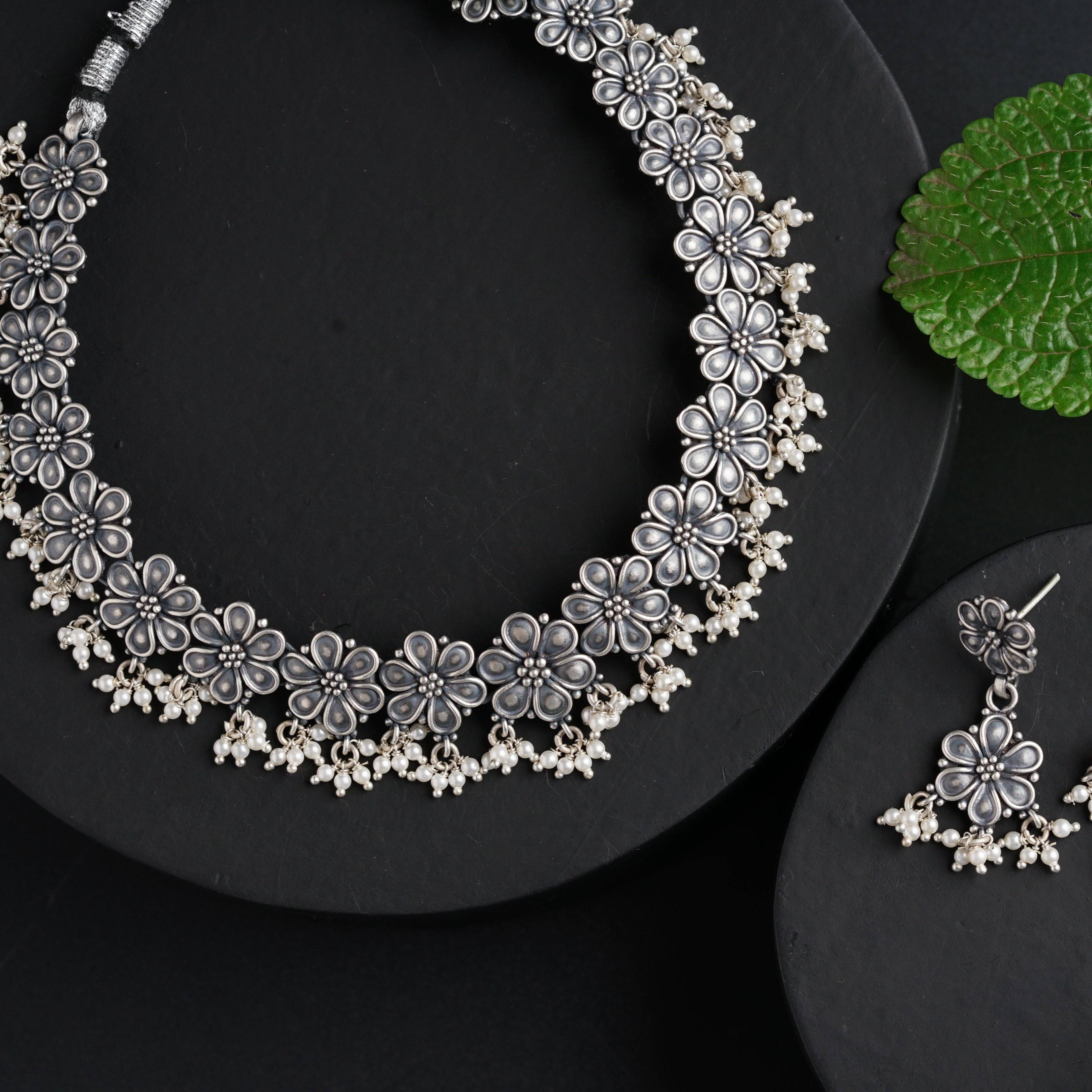 a close up of a necklace and earrings on a plate