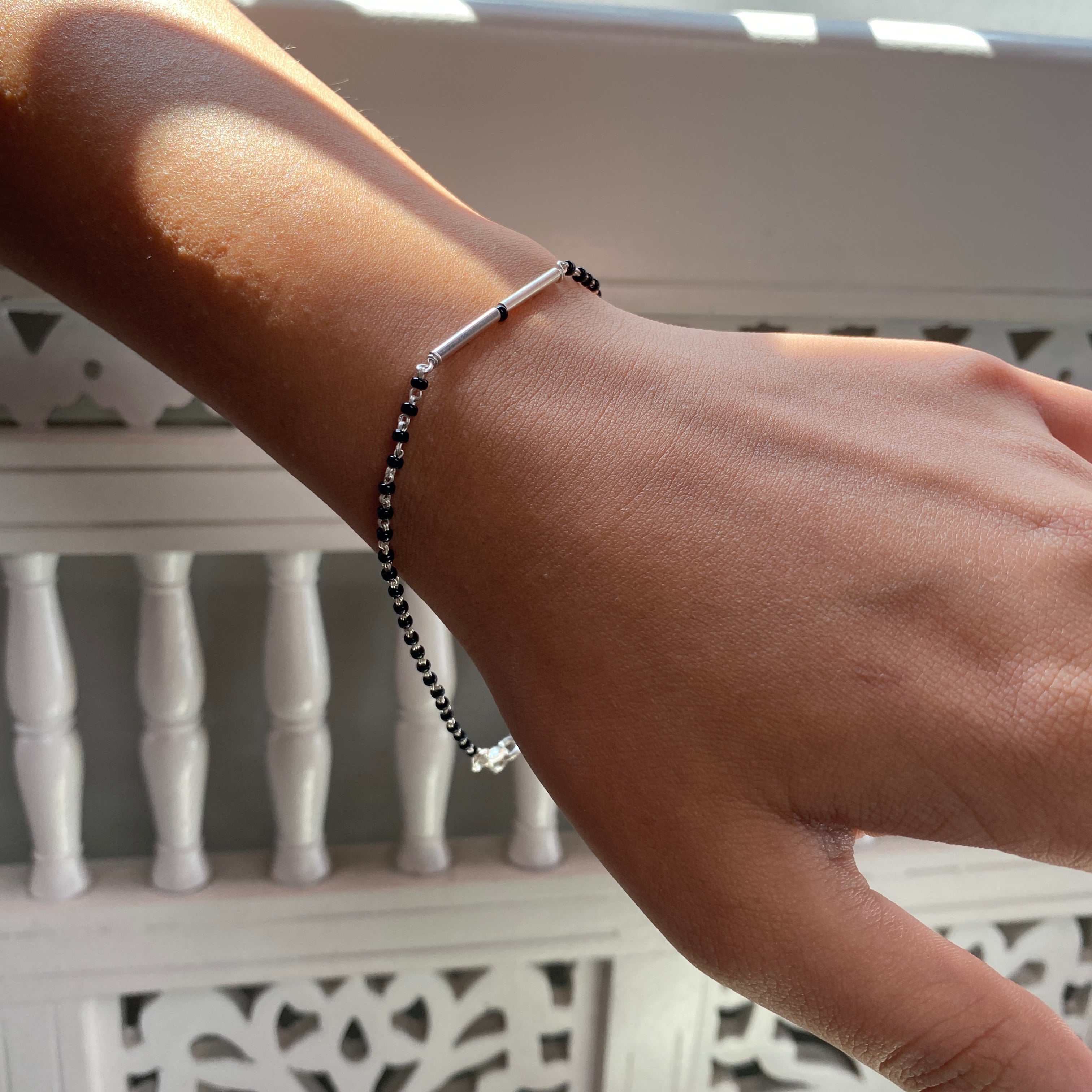 a person wearing a bracelet with a cross on it