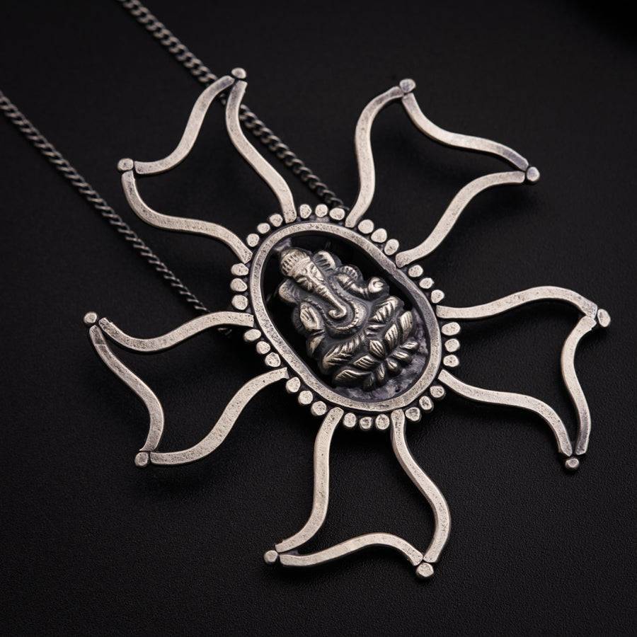 a necklace with a sun design on it