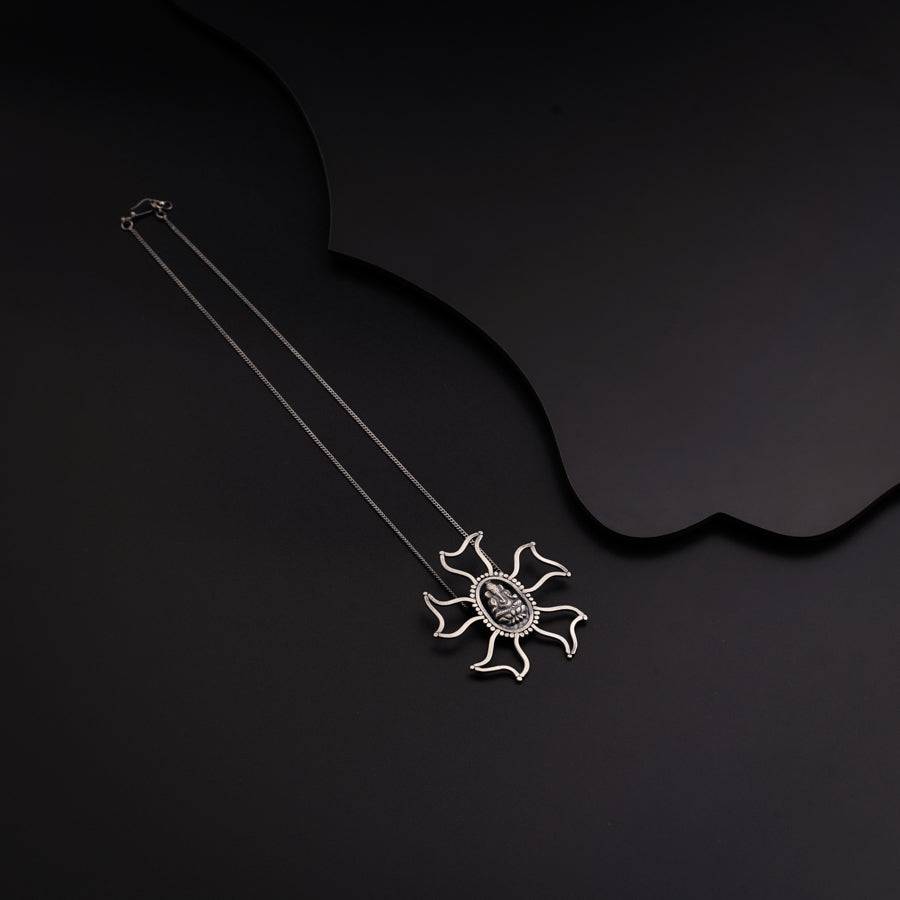 a silver necklace with a spider on it
