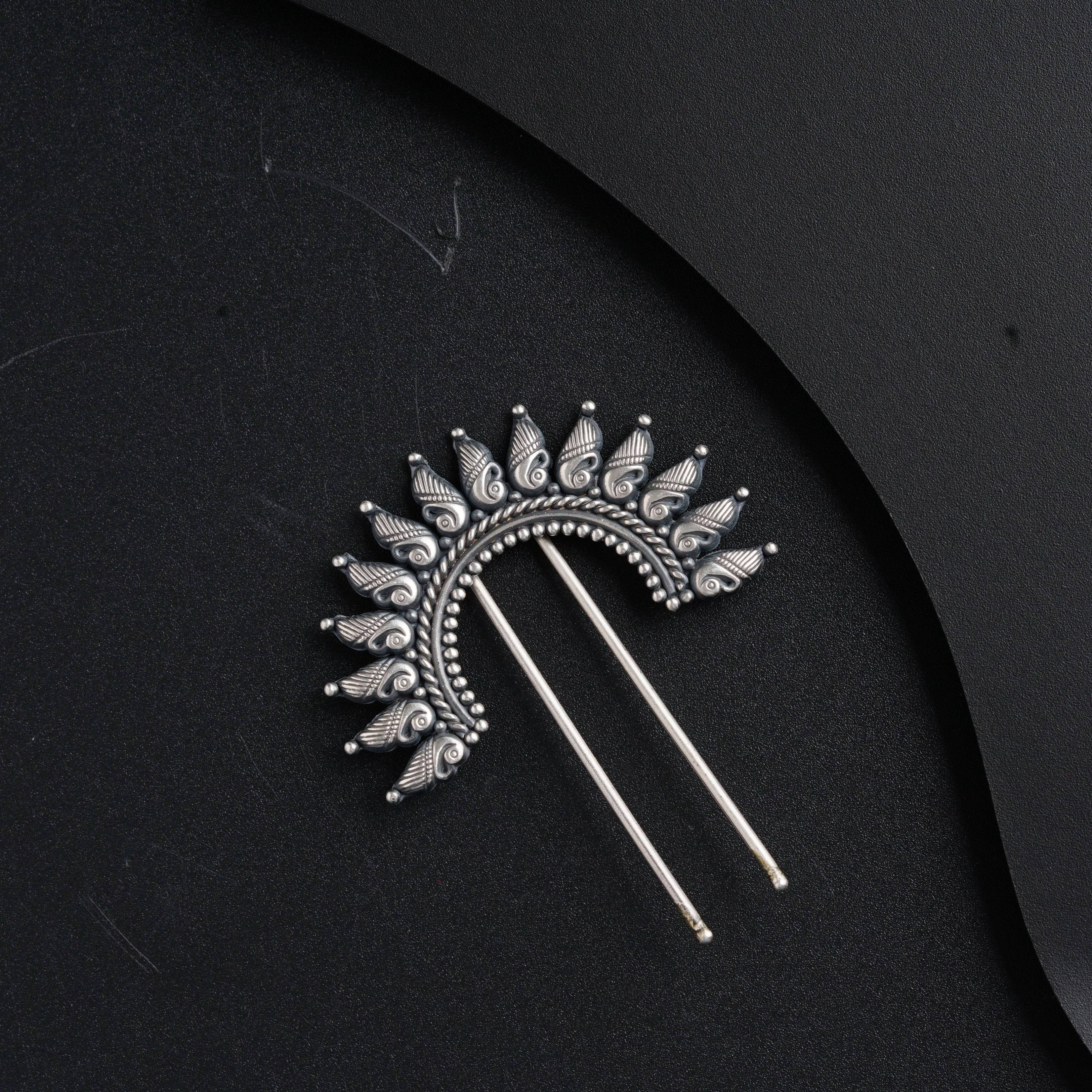 a pair of hair pins sitting on top of a black surface