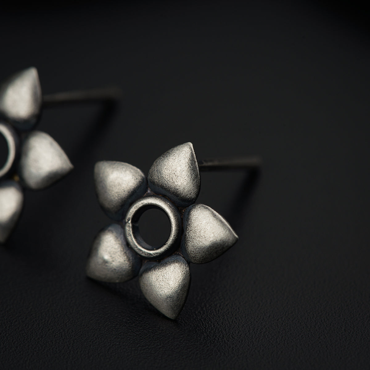 a pair of silver earrings sitting on top of a table