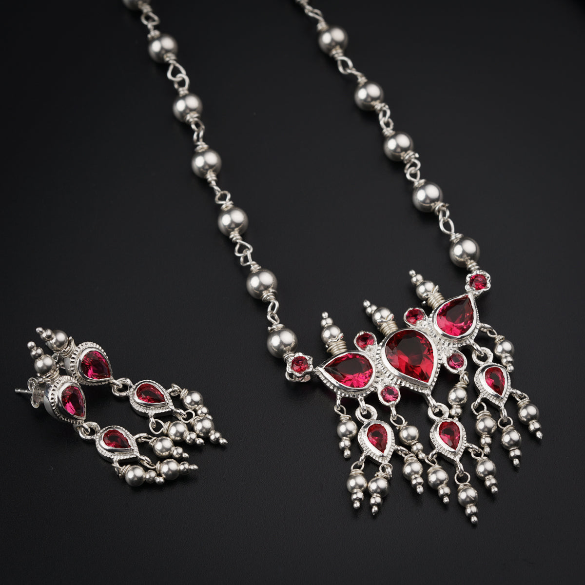 a close up of a necklace and earrings on a table